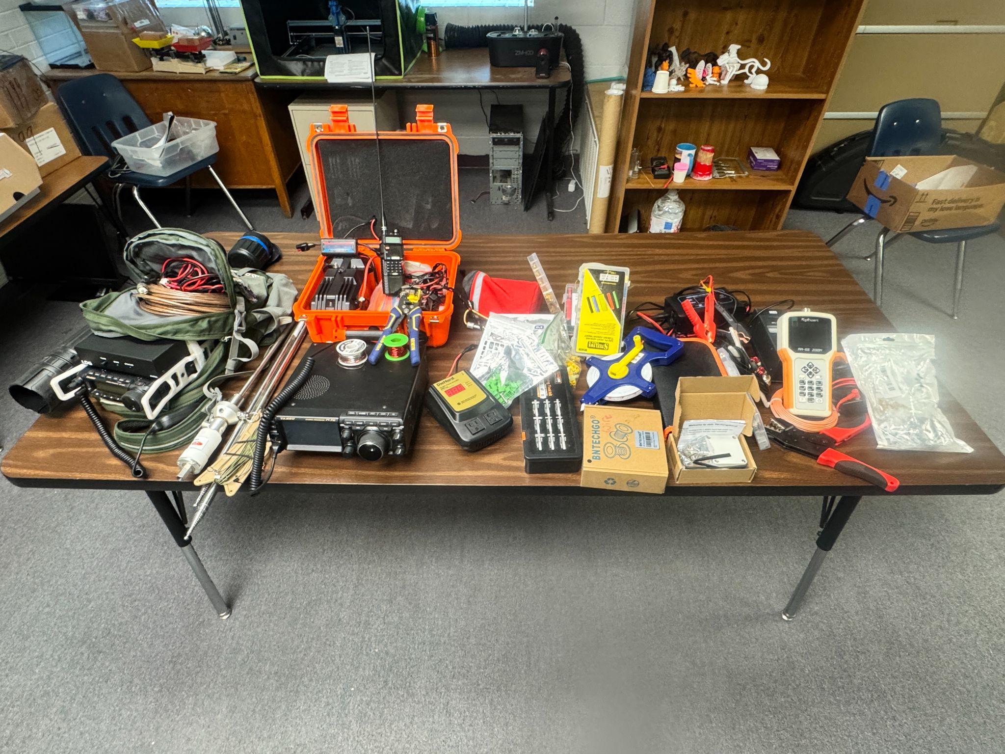 A table filled with multiple transceivers and other portable operations gear, Panthers Amateur Radio Club (PARC).
