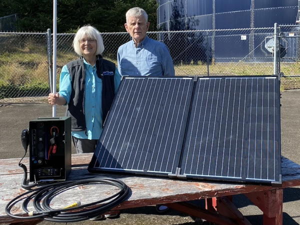 Margaret Steele, KG7RQZ, and Bruce Maxwell, N5GB, demonstrate the use of an Emergency Volunteer Corps of Nehalem Bay (EVCNB) solar-powered go-box