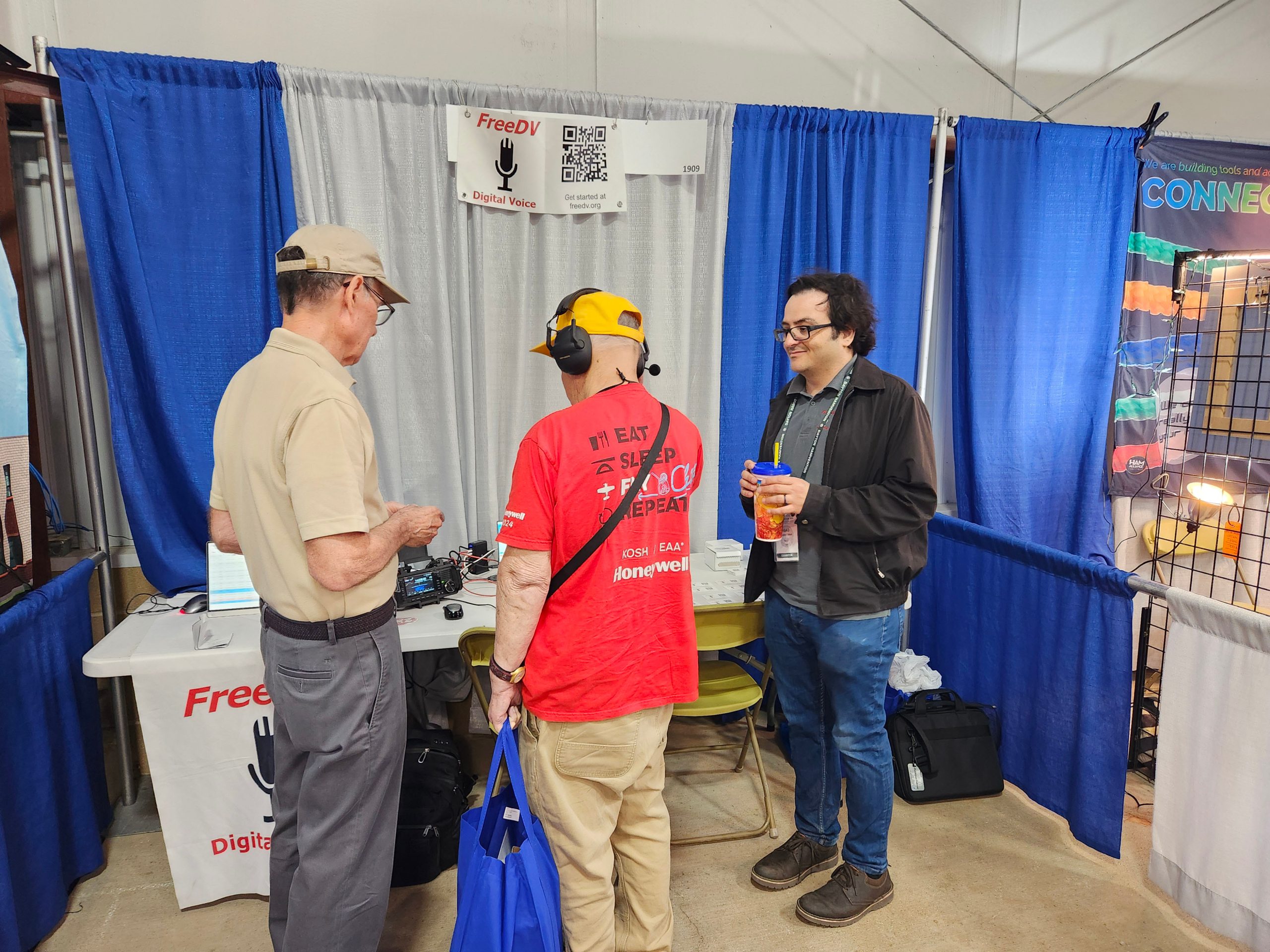Mel Whitten K0PFX and Mooneer Salem K6AQ of FreeDV demonstrating their Radio Autoencoder (RADE) to booth visitors, Hamvention 2025