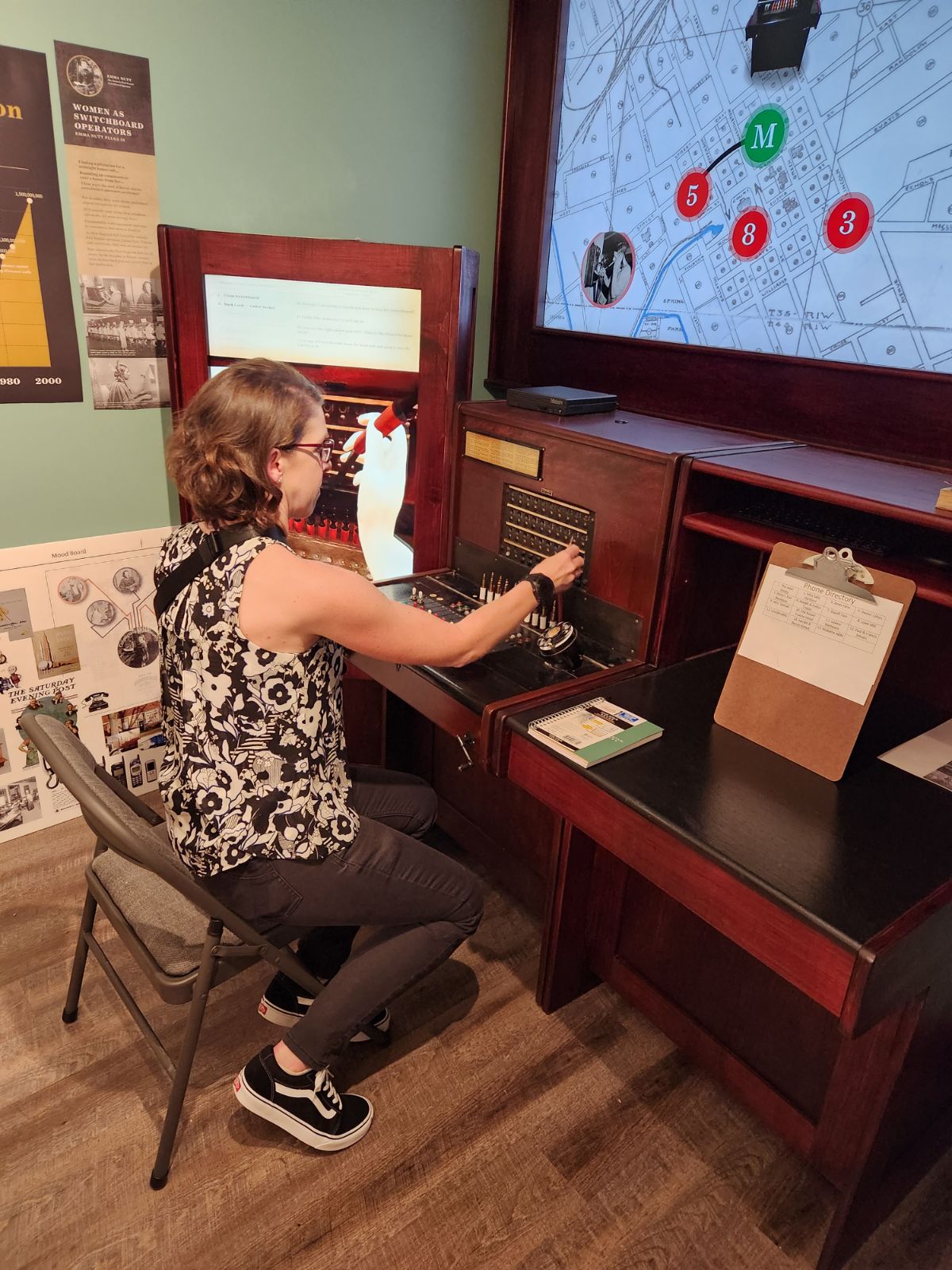 Rebecca Key (KO4KVG) participating in an interactive game at SIGNALS: Museum of Information Explosion that involves operating a switchboard circa 1928
